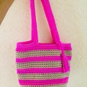 handmade crochet tote bag held up against a clean