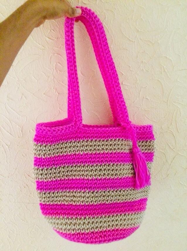 handmade crochet tote bag held up against a clean